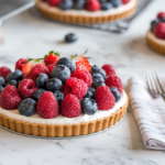 Fruit tart topped with fresh berries on a cream cheese filling base.