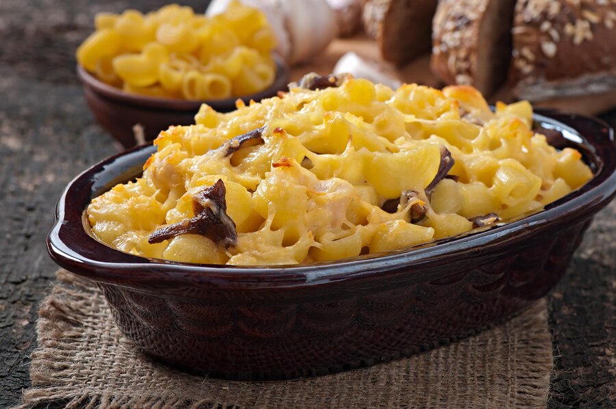 A freshly baked macaroni and cheese dish with a golden breadcrumb crust served in a vintage casserole dish.