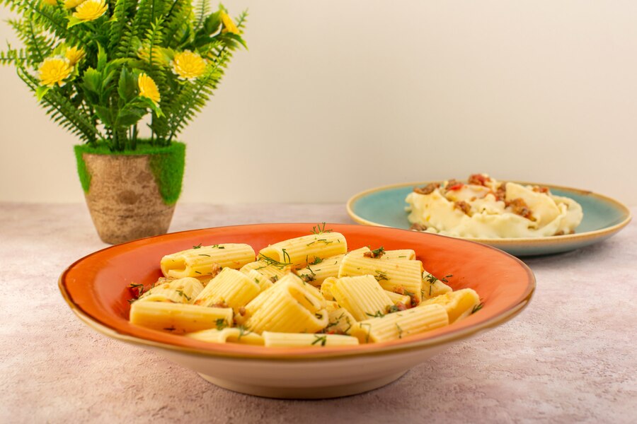 A serving of baked macaroni and cheese with a crisp green salad on a white plate.