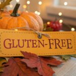 A food label marked gluten-free, placed next to a pumpkin and autumn leaves.