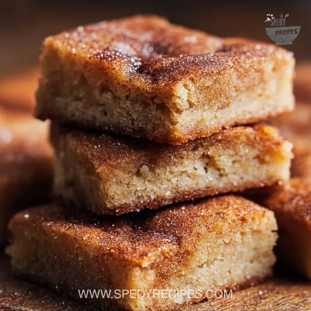 Cinnamon Sugar Blondies Delicious cinnamon sugar blondies served on a plate, topped with a sprinkle of cinnamon.