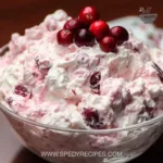 Cranberry Fluff Salad served in a bowl with cranberries and whipped cream