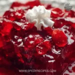 Delicious cranberry jello salad served in a glass bowl with fresh cranberries.