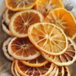 A close-up of dried orange slices arranged on a wooden table.