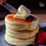 Fluffy Japanese soufflé pancakes served with syrup and fruit