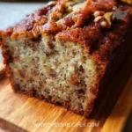 Delicious slice of the world's best banana bread on a wooden table.