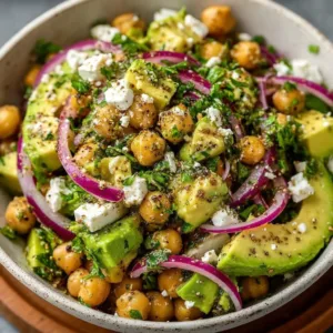 Colorful Chickpea Feta Avocado Salad with fresh vegetables in a bowl.