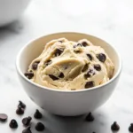 Bowl of delicious edible cookie dough with chocolate chips and a spoon