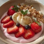 Healthy yogurt bowl topped with fresh fruits, nuts, and seeds.
