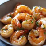 Plate of high-protein honey garlic shrimp garnished with green onions