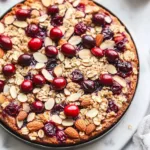 Delicious Almond Cranberry Cake with nuts and cranberries garnished on a plate