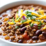 Bowl of classic slow cooker chili garnished with fresh herbs