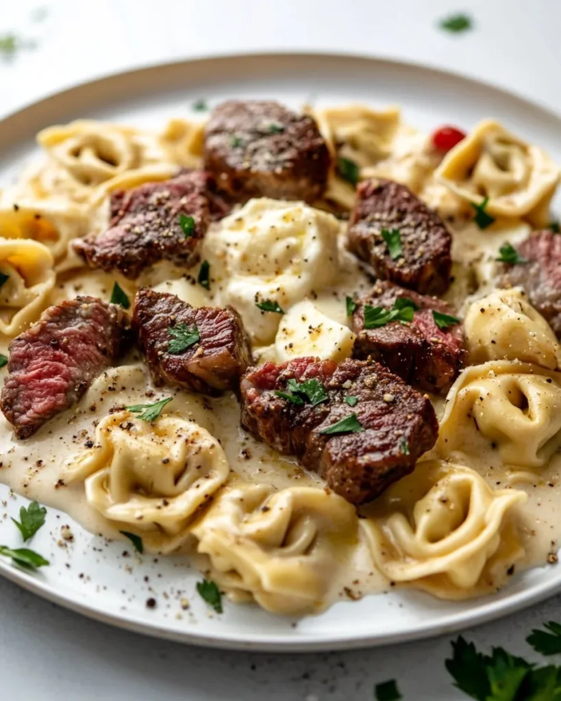 Delicious Garlic Steak Tortellini in creamy sauce, garnished with herbs.