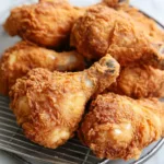 Plate of crispy spicy buttermilk fried chicken with golden brown coating.