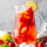 Hibiscus tea strawberry-lemonade refresher in a glass with lemon slices.