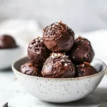 No-bake cottage cheese brownie batter protein bites on a white plate.
