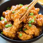 Plate of homemade Orange Chicken with a side of rice and vegetables