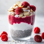 Creamy Raspberry Chia Pudding topped with fresh raspberries and drizzled with maple syrup