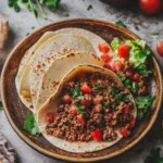Delicious slow cooker taco meat served in a bowl with toppings.
