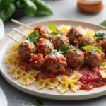 Bowtie pasta and cocktail meatball skewers on a serving platter