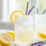 Coconut Lavender Lemonade mocktail served in a glass with fresh herbs and lemon slices.