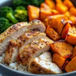 Healthy chicken and sweet potato rice bowl garnished with vegetables