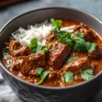 Bowl of slow cooker Indian beef curry with herbs and spices