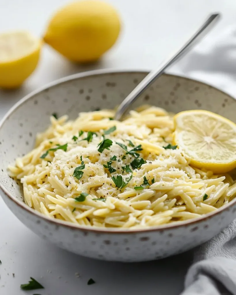 Delicious bowl of Lemon Orzo Pasta garnished with fresh herbs and lemon slices
