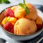 Delicious Mango Strawberry Sorbet served in a bowl with fresh fruit garnish