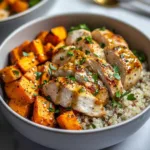 Delicious Maple Dijon Chicken served in a bowl with sweet potatoes and greens.