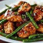 Delicious Honey Garlic Chicken served with sautéed green beans on a plate.