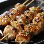Delicious Japanese chicken skewers glazed with a savory marinade on a grill.