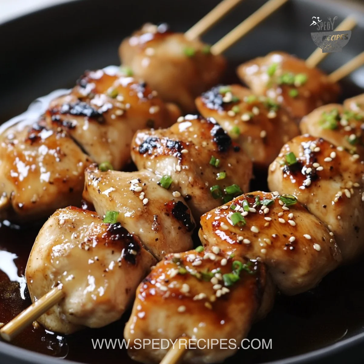 Delicious Japanese chicken skewers glazed with a savory marinade on a grill.