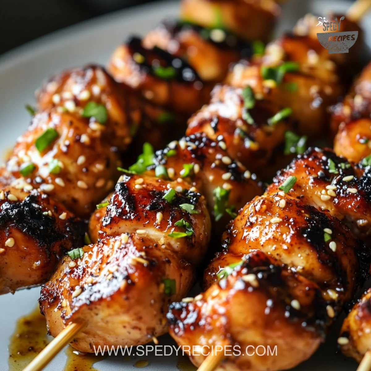 Delicious sticky bourbon chicken skewers served on a platter.