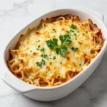 A delicious plate of million dollar spaghetti topped with cheese and herbs
